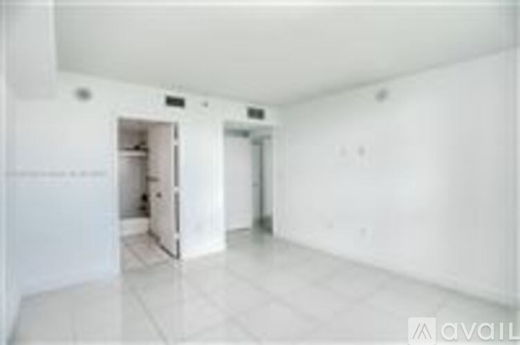 A white room with a doorway leading to another room.