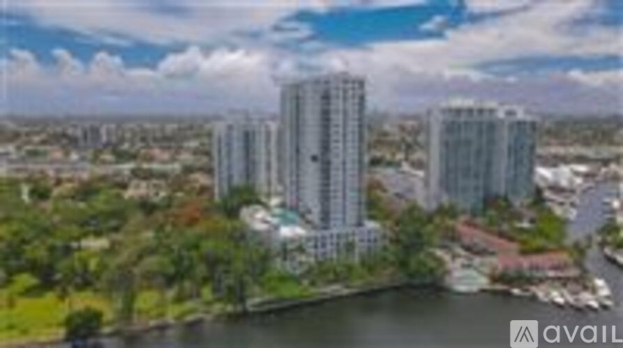 A cityscape with tall buildings and a body of water in the foreground.