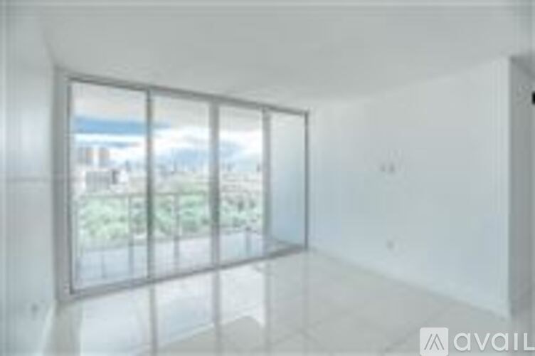 A room with a large window overlooking a green landscape.