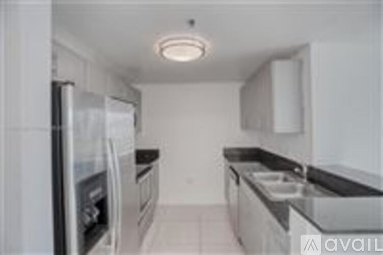A kitchen with a refrigerator, oven, and sink.