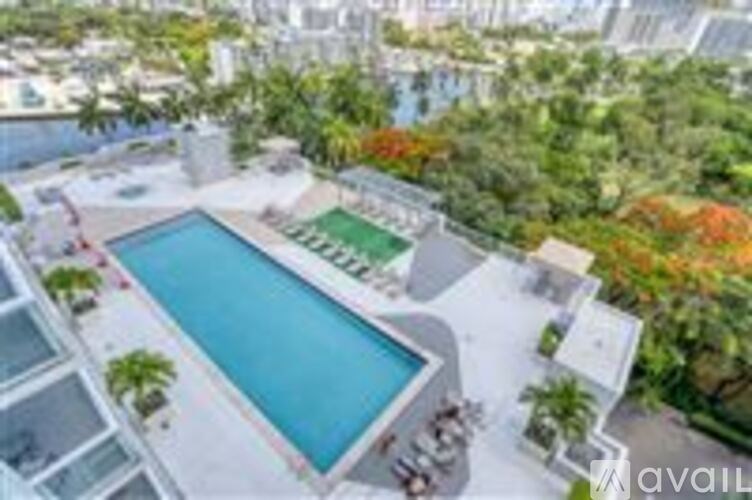 A pool surrounded by trees and buildings.