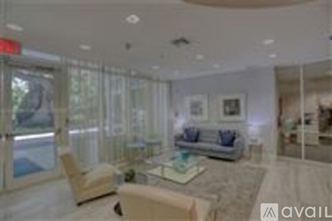A living room with a couch, chair, and glass doors.
