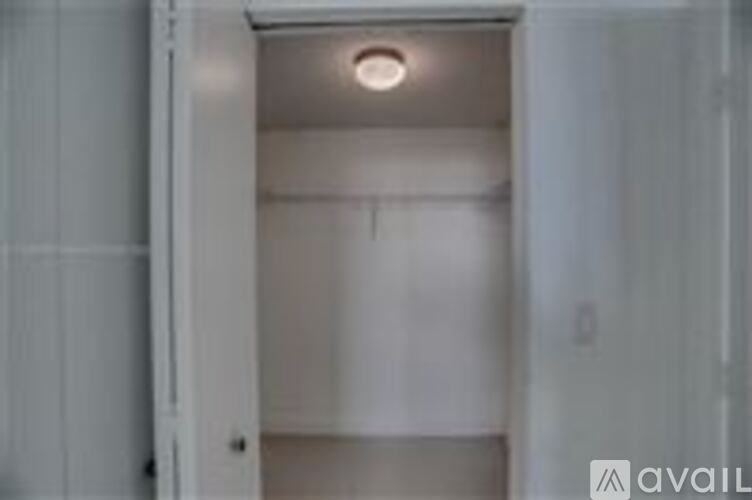 A white door is open to a room with a light on the ceiling.