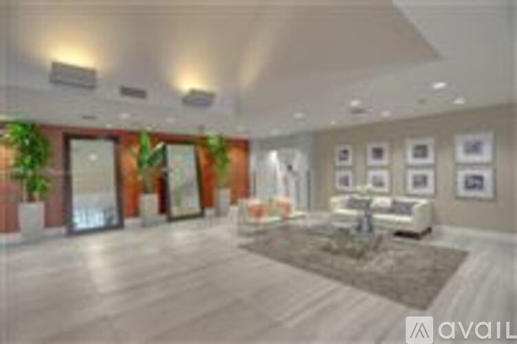 A spacious living room with a couch, coffee table, and pictures on the wall.