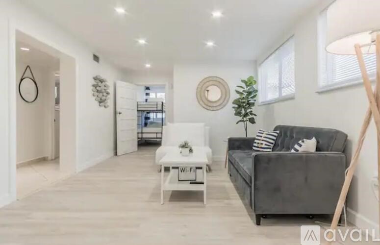 A modern living room with a grey couch and a white coffee table.