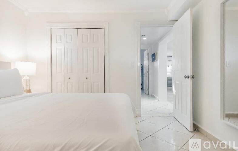 A bedroom with a large bed and a white door.