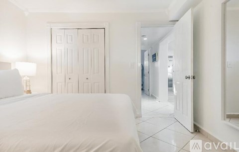A bedroom with a large bed and a white door.