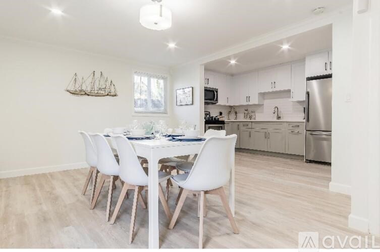 A dining room with a white table and chairs.