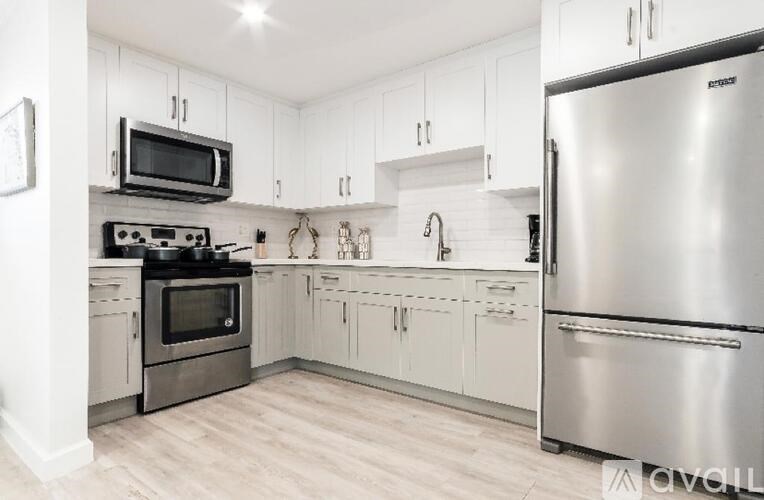 A kitchen with a stove top oven and a refrigerator.