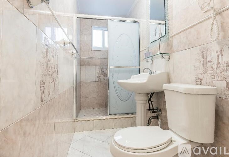 A bathroom with a toilet, sink, and shower.