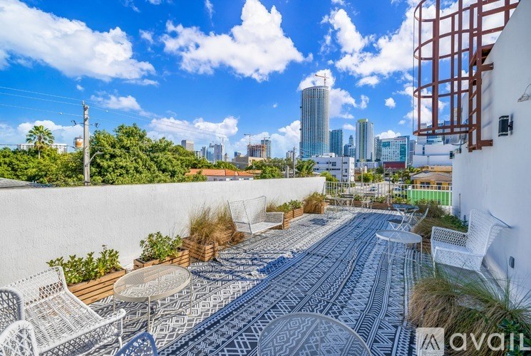 A patio with a table and chairs overlooks a city skyline.