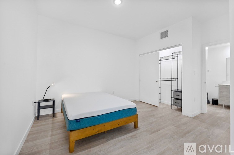 A bedroom with a bed, a chair, and a wardrobe.