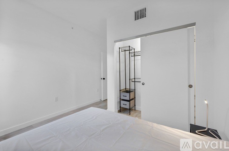 A bedroom with a bed, nightstand, and a chair.