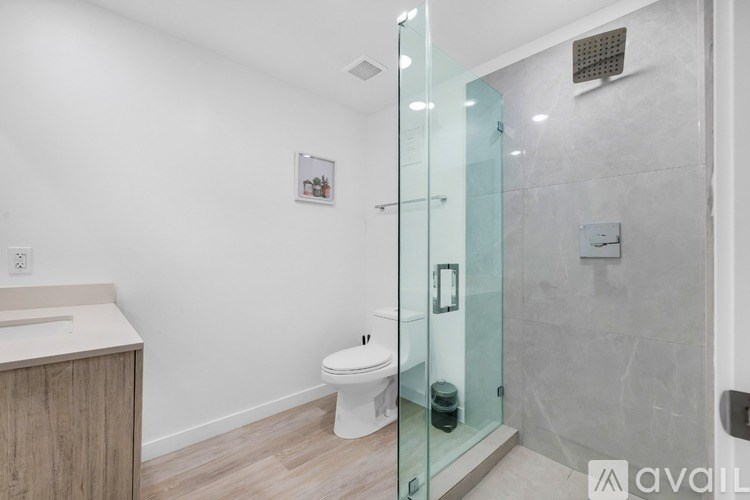 A bathroom with a glass shower door and a white toilet.