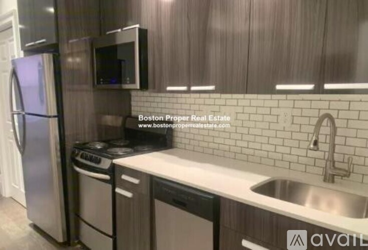 A kitchen with a refrigerator, microwave, dishwasher, and stove top oven.