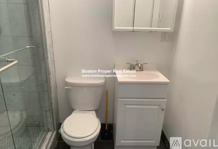 A white toilet and sink in a small bathroom.