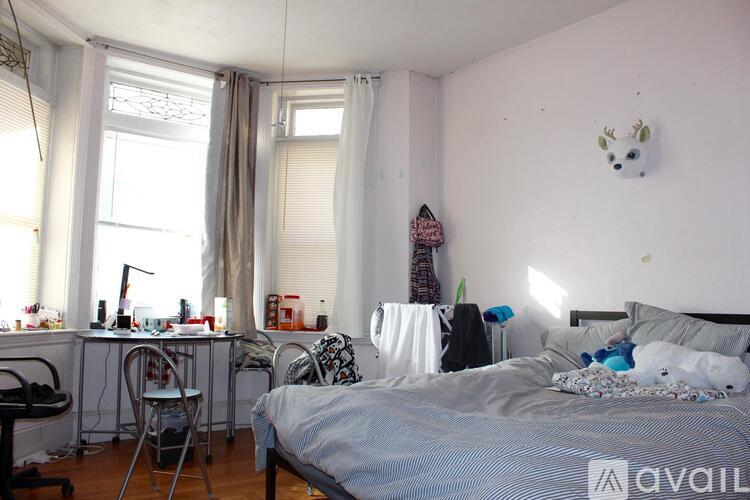 A bedroom with a bed, desk, and chair.