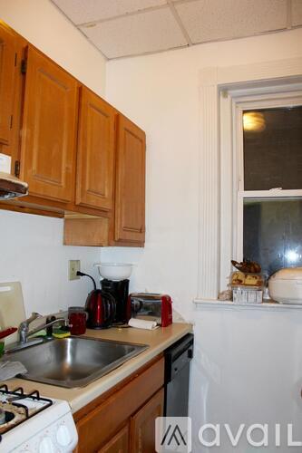 A kitchen with wooden cabinets and a white stove top.