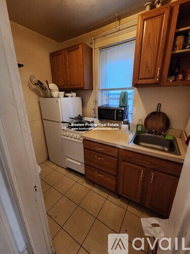 A kitchen with wooden cabinets and a white refrigerator.