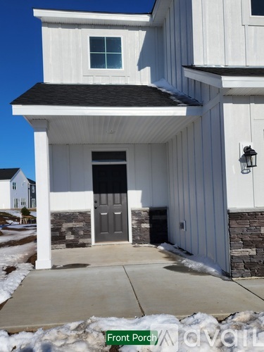 A white house with a black door and a porch.