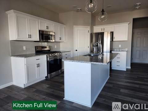 A kitchen with white cabinets and a large island.