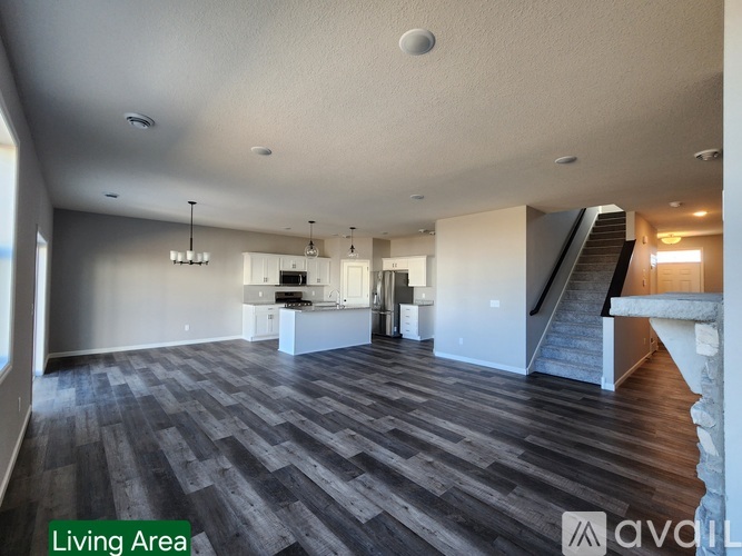 A spacious living area with a staircase on the right.