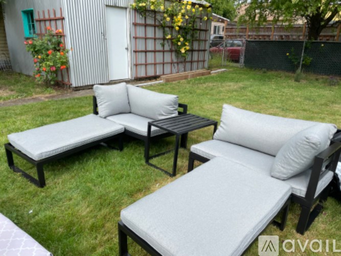 A black and white outdoor furniture set is on a grassy area.