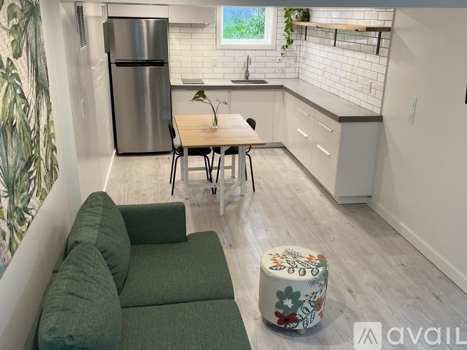 A kitchen with a green couch and a wooden table.