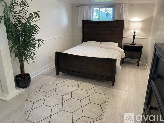 A bedroom with a large bed and a potted plant.