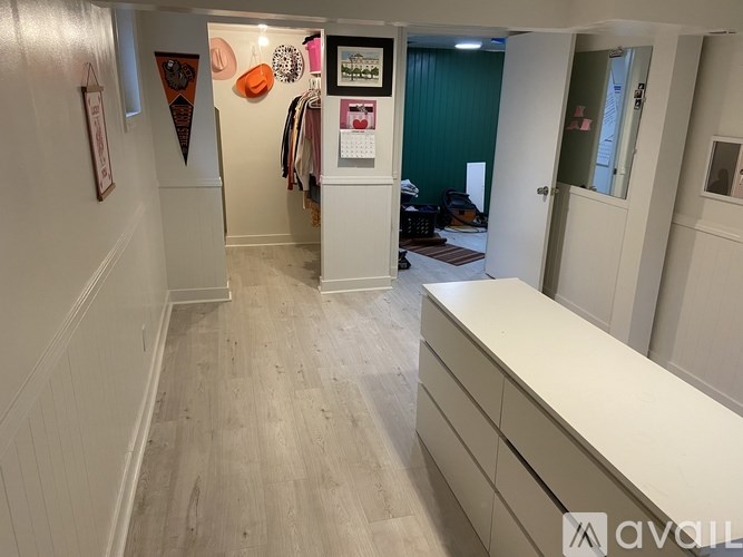 A hallway with a white counter on the right and a green wall in the background.