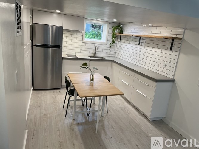 A kitchen with a table and chairs and a fridge.