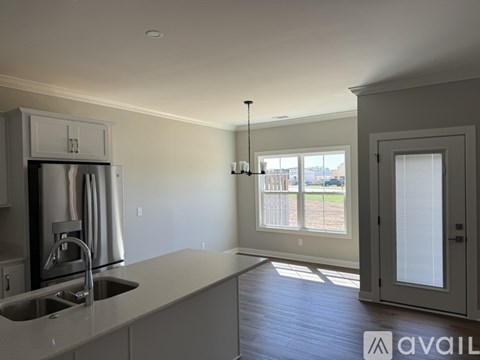 A kitchen with a sink and a refrigerator.