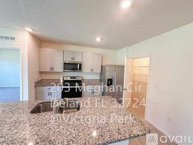 A kitchen with a granite countertop and a sink is shown.