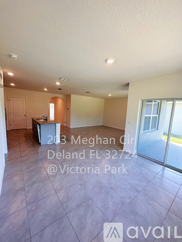 A spacious room with tiled flooring and a large window.
