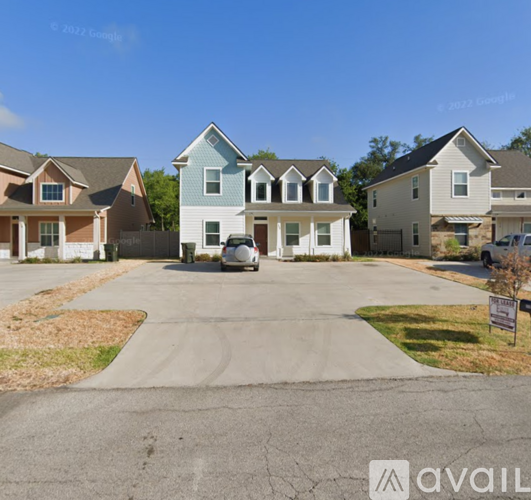 A row of houses with a car parked in the driveway.