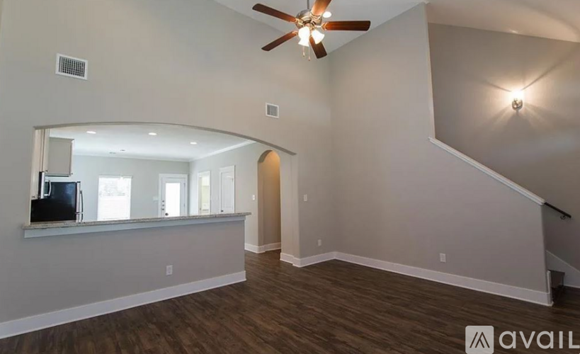A living room with a television and a staircase.
