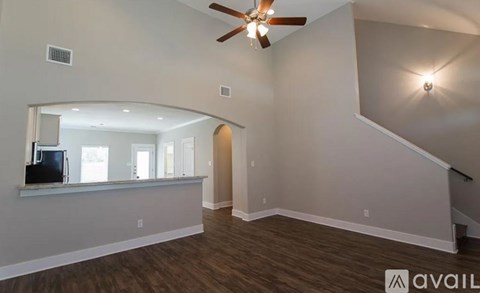 A living room with a television and a staircase.