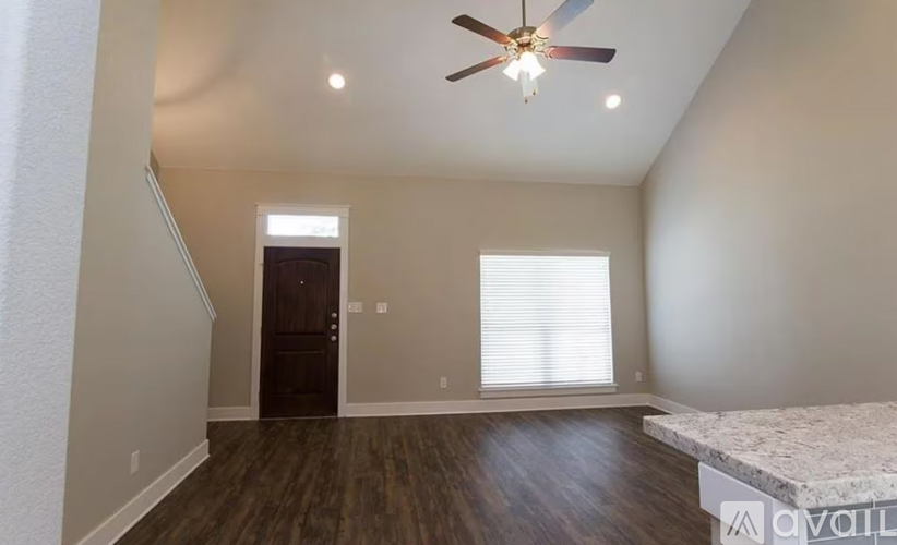 A room with a ceiling fan and a bed in it.
