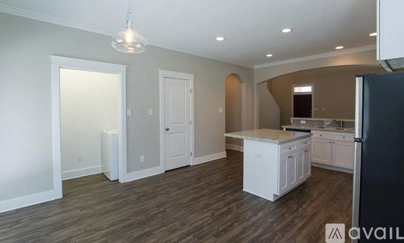 A kitchen with white cabinets and a black refrigerator.