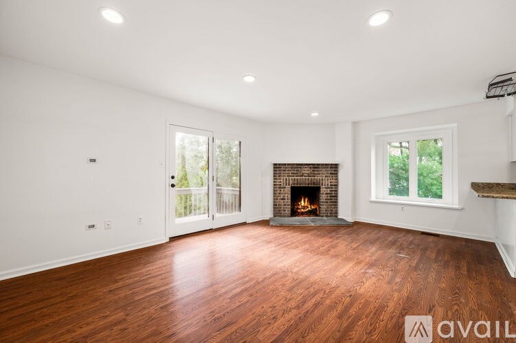 A spacious living room with a fireplace and wood flooring.