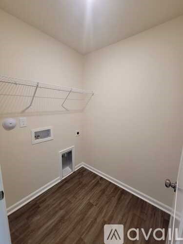 A room with a white door and a white wall with a vent.