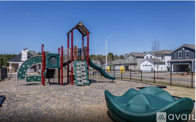 A playground with a green slide and a red and green play structure.