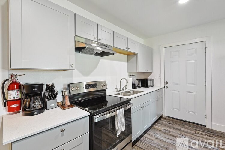 A kitchen with white cabinets and a black stove top oven.