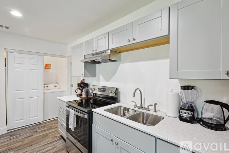 A kitchen with white cabinets and a black stove top oven.