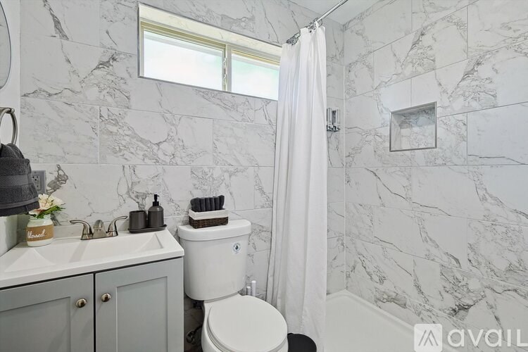 A bathroom with a toilet, sink, and shower.