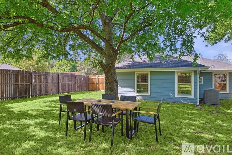A blue house with a tree in the yard.