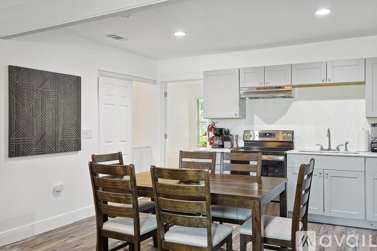 A dining room with a wooden table and chairs.
