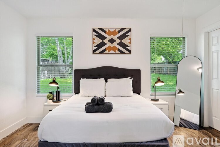 A bedroom with a large bed and a painting on the wall.