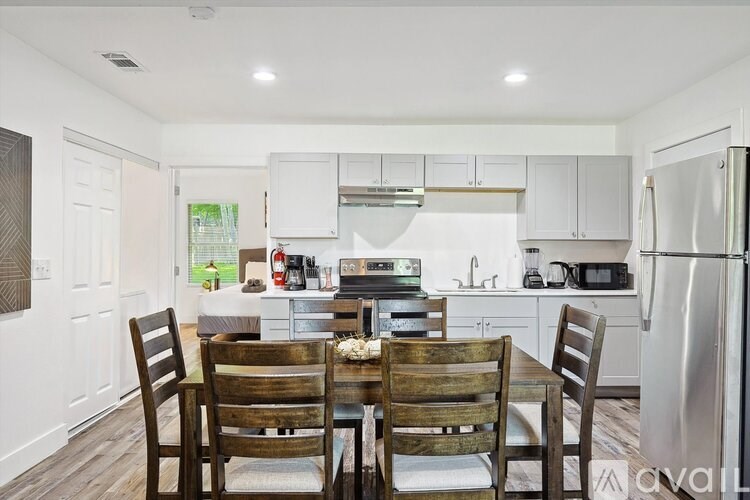 A kitchen with a table and chairs in front of it.
