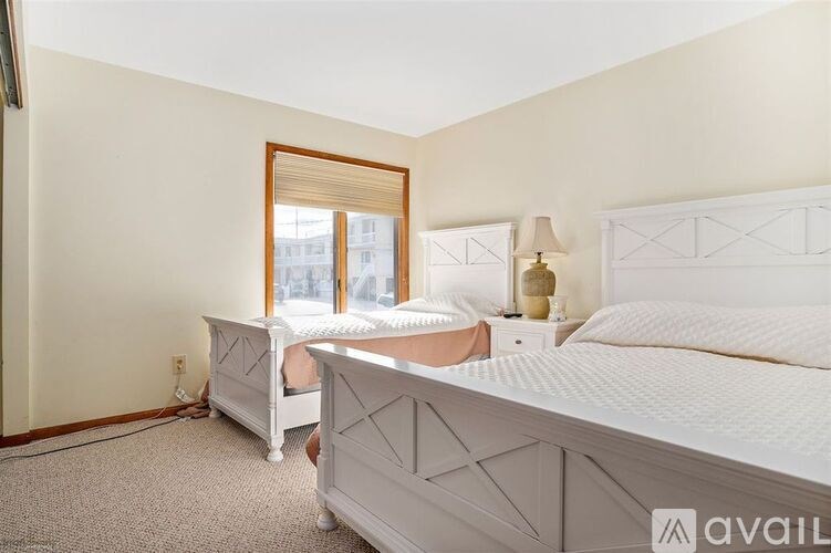 A bedroom with two beds and a window.